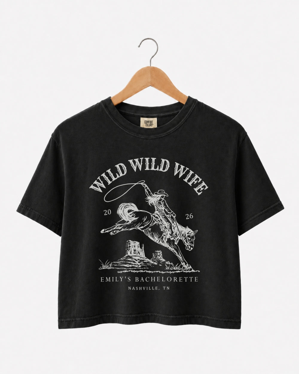 Matching crop tops for the Wild Wild Wife bachelorette crew, vintage western rodeo art with retro script. Personalized with bride name, date, and city for the full party.
