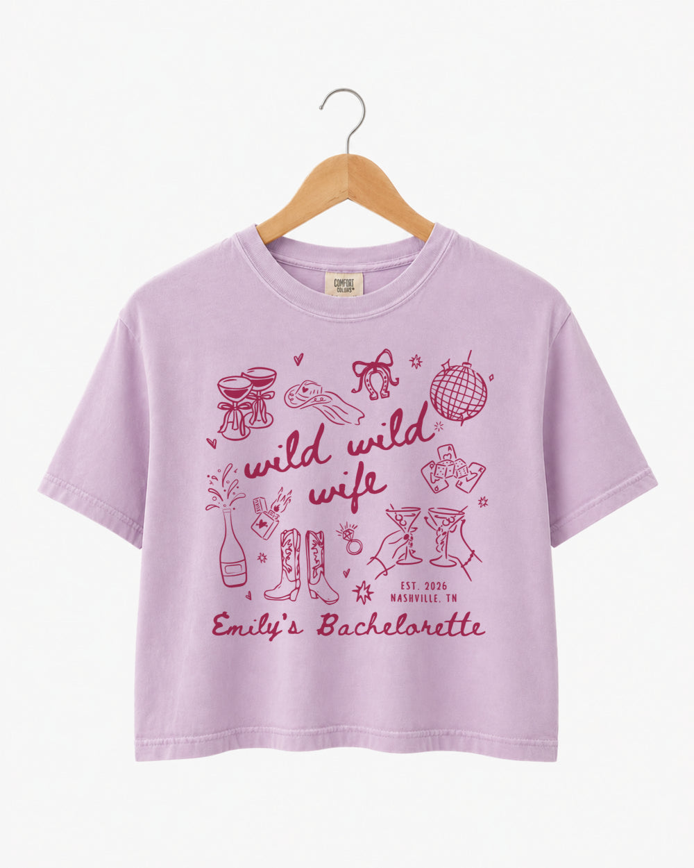 Maid-of-honor gift idea: Wild Wild Wife bachelorette crop top with playful doodle art and script lettering. Personalized with bride name, weekend date, and destination city for the whole crew.