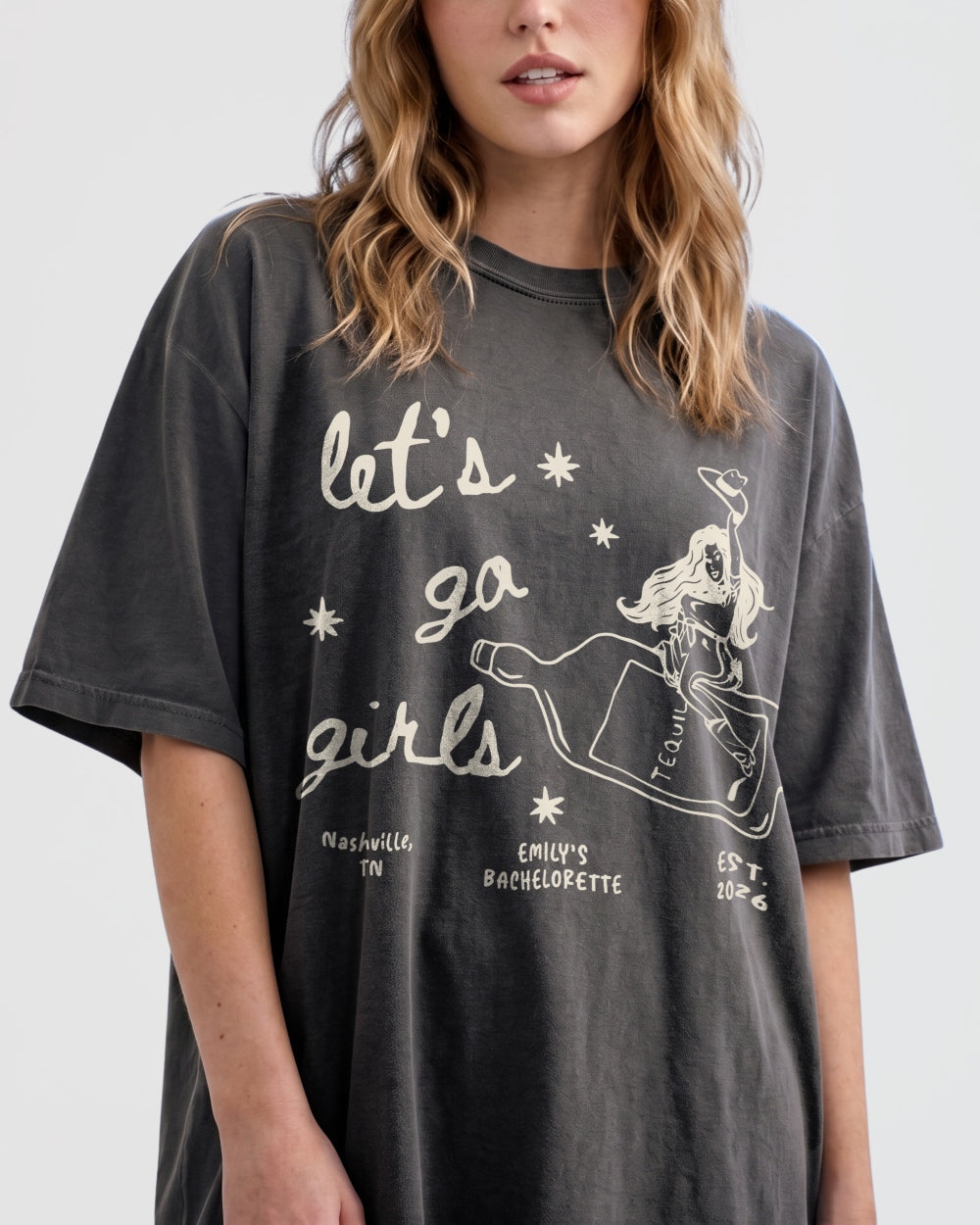 Girls night out tee with vintage cowgirl bottle illustration and Let's Go Girls script. Casual statement shirt for bar crawls, country concerts, and bachelorette weekends.