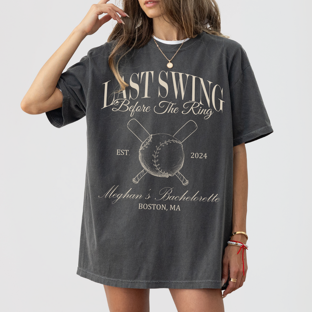Charcoal gray 'Last Swing Before The Ring' bachelorette t-shirt with baseball design, featuring personalized text for Meghan's Bachelorette in Boston