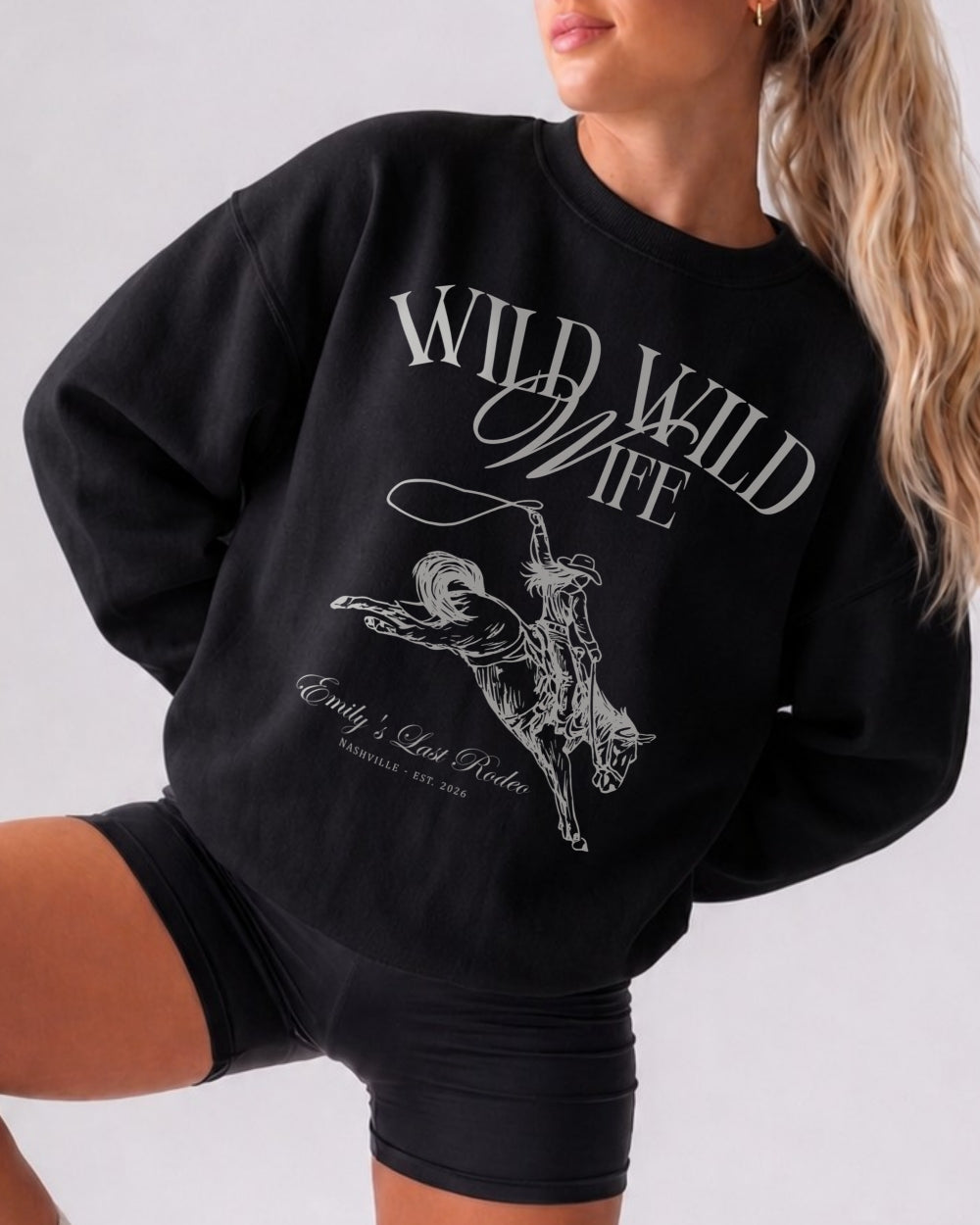Bride and bridesmaids matching country western sweatshirts for a Wild Wild Wife bachelorette weekend. Vintage rodeo illustration with location and year customizable for the full crew.