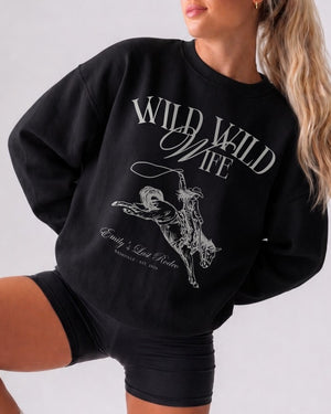 Bride and bridesmaids matching country western sweatshirts for a Wild Wild Wife bachelorette weekend. Vintage rodeo illustration with location and year customizable for the full crew.