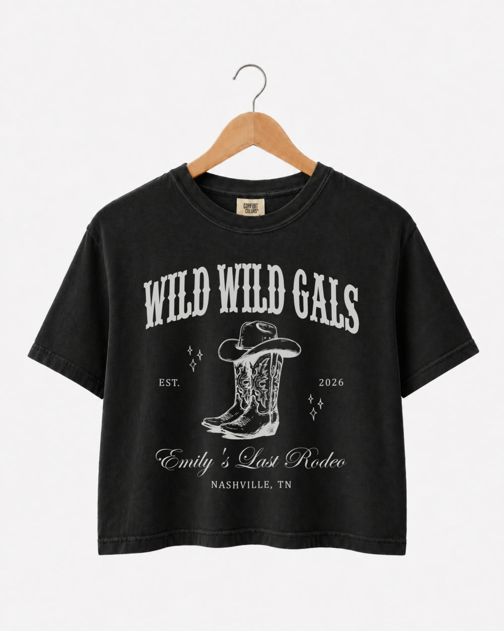 Matching crop tops for a cowgirl bachelorette crew, Wild Wild Wife western theme with vintage script art. Personalized with bride name, year, and destination city for the whole party.