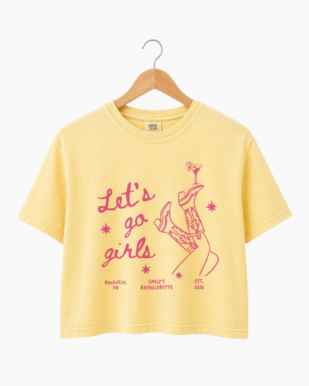 Personalized girls night out crop top with vintage line-art illustration of cowboy boots and martinis. Custom name or phrase on a Let's Go Girls bachelorette or girls trip tee.