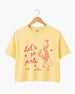 Personalized girls night out crop top with vintage line-art illustration of cowboy boots and martinis. Custom name or phrase on a Let's Go Girls bachelorette or girls trip tee.