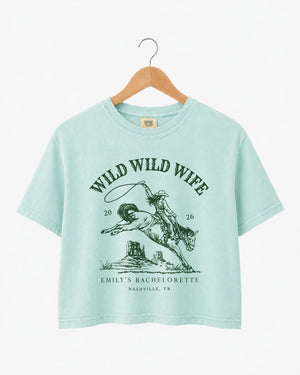 Maid-of-honor gift idea: Wild Wild Wife bachelorette crop top with vintage western art. Personalize with the bride's name, year, and destination city for the full rodeo crew.