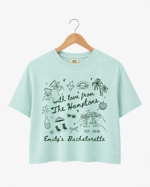 Gift idea for the bachelorette crew: Hamptons-themed crop top with playful illustrated doodles and script lettering. Personalized with bride name, destination, and weekend year for the whole party.