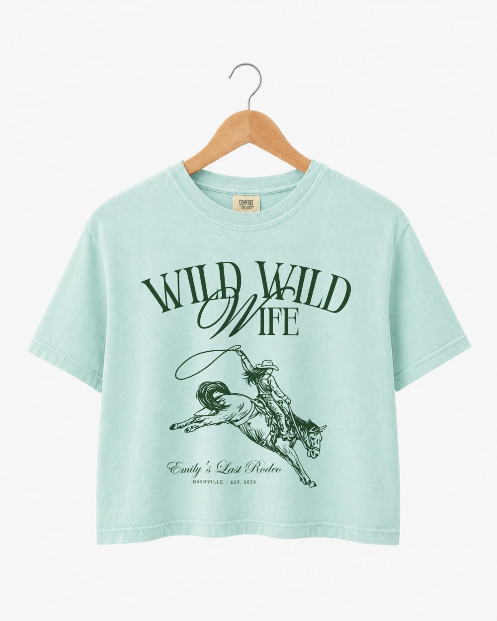 Gift idea for the bride: Wild Wild Wife cowgirl bachelorette crop top with vintage western art. Personalized with bride name, destination, and year for the whole crew.