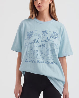 Whimsical doodle-art bachelorette tee with script lettering and hand-drawn line-art motifs, Wild Wild Wife theme. Personalized matching set for the bride and her crew, name and weekend details customizable.