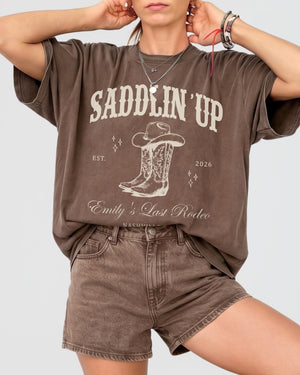 Bride and bridesmaids matching western bachelorette tees with vintage cowboy boot illustration for a Last Rodeo rodeo-theme party. Personalized with bride name, year, and destination city.