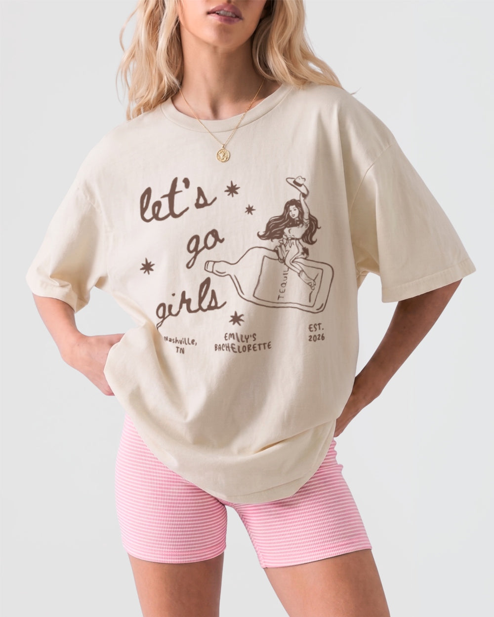 Girls night out tee with vintage line-art cowgirl bottle graphic and Let's Go Girls script. Casual crew matching shirt for bar nights, honky-tonks, and bachelorette weekends.
