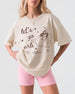 Girls night out tee with vintage line-art cowgirl bottle graphic and Let's Go Girls script. Casual crew matching shirt for bar nights, honky-tonks, and bachelorette weekends.