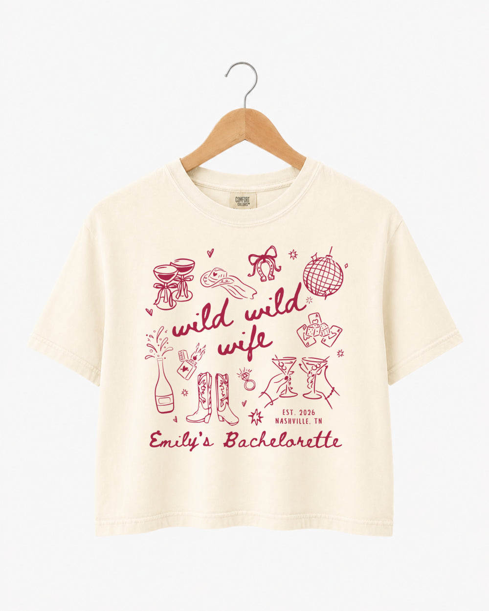Bachelorette weekend crop top with Wild Wild Wife theme, playful line-art doodles, and script lettering. Personalized with bride name, EST year, and destination city for the whole crew.