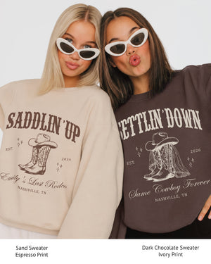 Personalized western bachelorette sweatshirt with bride name, year, and destination city in vintage serif typography. Custom Saddlin' Up design for the whole bachelorette crew.