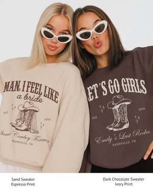 Personalized bachelorette sweatshirt with bride name, year, and destination city on a country western Last Rodeo theme. Bold pink serif type and cowboy boot art for the Nashville-bound bride squad.