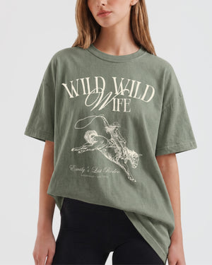 Vintage western-cut bachelorette tee with rodeo bride illustration and Wild Wild Wife script lettering, made for the bride and her crew at a western or cowgirl-themed bachelorette party.