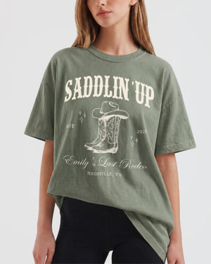 Boxy western bachelorette t-shirt with vintage rodeo illustration and cowboy boot art for the Last Rodeo crew. Personalized with bride name, date, and city for the full party.