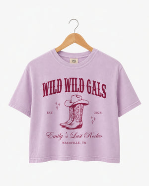Bride and bridesmaids matching crop tops for a Wild Wild Wife cowgirl bachelorette party. Vintage western doodle art with script typography, personalized with name, year, and destination city.