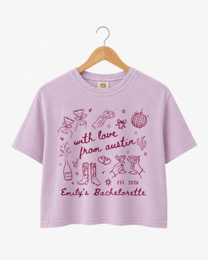 Bride and bridesmaids in matching bachelorette crop tops with minimalist doodle script art. Personalized with the bride's name, year, and city for the full Austin-inspired crew.