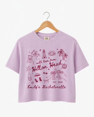 Bride and bridesmaids matching crop tops for a Hilton Head bachelorette weekend. Playful doodle art with hand-drawn script, personalized with bride name, destination, and date for the whole crew.