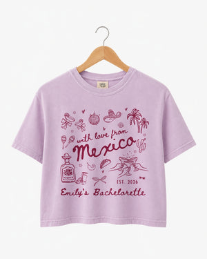 Bride and bridesmaids in matching Mexico bachelorette crop tops with playful hand-drawn script art. Personalized with bride name, destination, and year for the full crew.