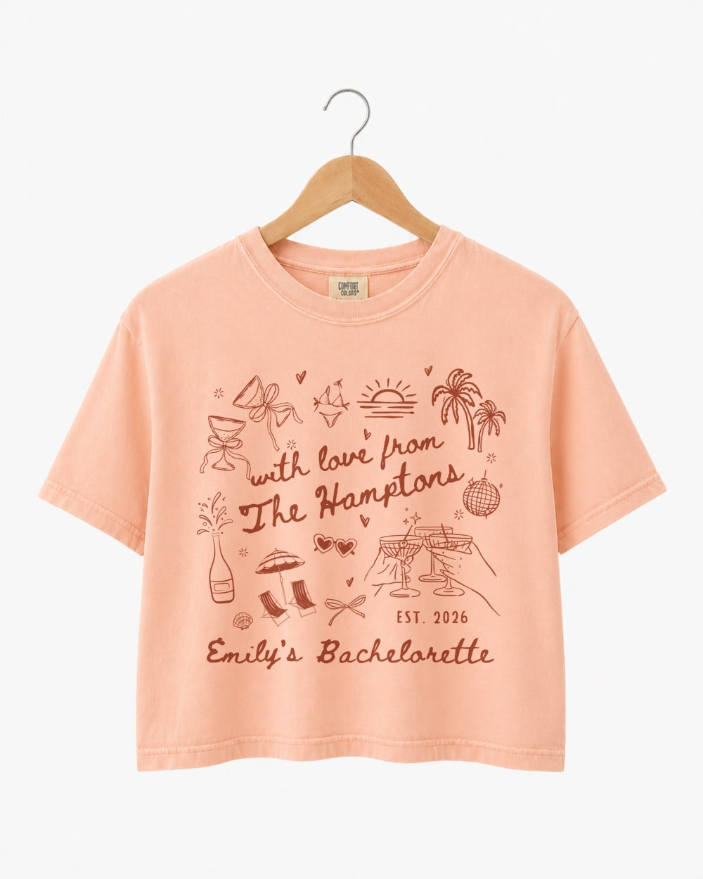 Playful illustrated doodle bachelorette crop top with script lettering and hand-drawn art, Hamptons weekend theme. Personalized with bride name, date, and destination for the whole crew.