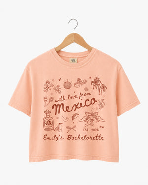 Playful hand-drawn line art bachelorette crop top with script lettering and a Mexico destination theme. Personalized with bride name, year, and destination for the whole crew.