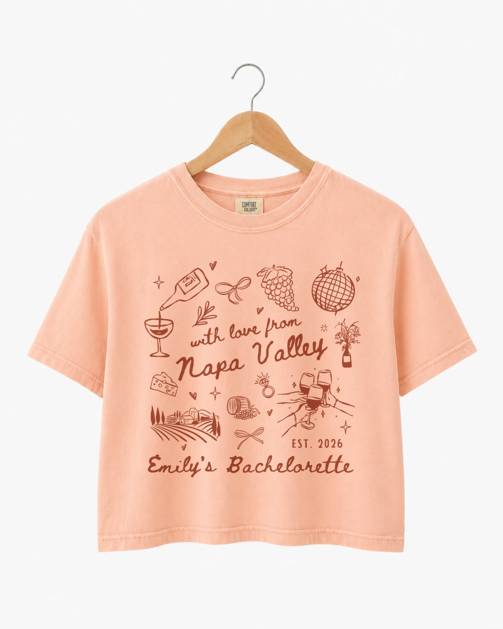 Whimsical line-art doodle bachelorette crop top with script typography and Napa Valley wine weekend theme. Personalized with bride name, year, and destination for the full bridal crew.