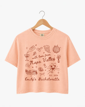 Whimsical line-art doodle bachelorette crop top with script typography and Napa Valley wine weekend theme. Personalized with bride name, year, and destination for the full bridal crew.
