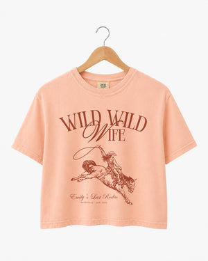 Vintage western illustration bachelorette crop top with script typography and rodeo art. Personalized with bride name, destination city, and year for the whole bachelorette crew.