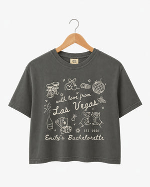 Cropped bachelorette top with vintage line-art illustration and script lettering for a Las Vegas girls weekend. Personalized with bride name, year, and destination city for the whole crew.