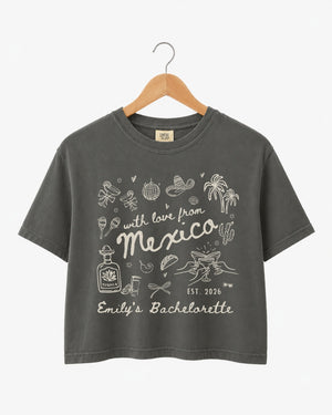 Cropped bachelorette top with playful hand-drawn script art for a Mexico destination weekend. Personalized with bride name, bachelorette title, and year for the full crew.