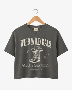 Vintage western script bachelorette crop top with cowgirl bride illustration, Wild Wild Wife theme. Personalized with bride name, est. year, and destination city for the full crew.