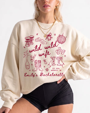 Bachelorette weekend sweatshirt with Wild Wild Wife doodle theme for the bride and her crew. Personalized with bride name, date, and destination city for the full matching set.