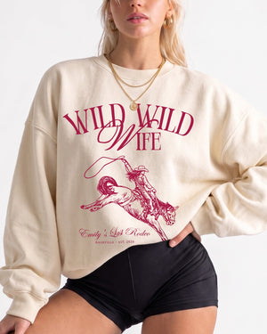 Country western bachelorette sweatshirt with vintage rodeo illustration and Wild Wild Wife script. Bride name, location, and year customizable for the whole bridal crew.