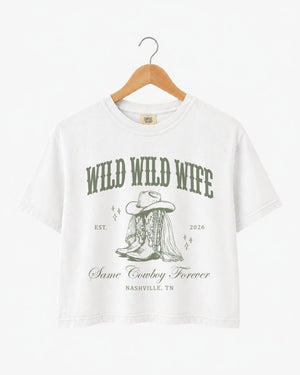 Bachelorette weekend crop top with vintage western illustration and cowgirl bride theme. Wild Wild Wife design with script typography, personalized with bride name, year, and destination city.