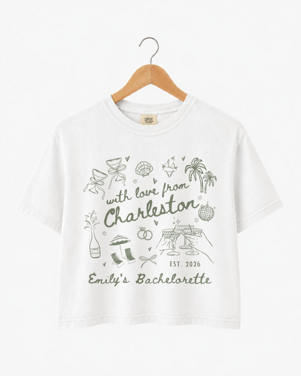 Bachelorette weekend crop tops with hand-drawn doodle script and playful icons for the Charleston bride crew. Personalized with bride name, destination city, and EST year for the full party.