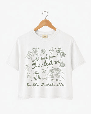 Bachelorette weekend crop tops with hand-drawn doodle script and playful icons for the Charleston bride crew. Personalized with bride name, destination city, and EST year for the full party.