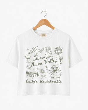 Napa Valley bachelorette weekend crop top with whimsical wine-country doodle art and script lettering. Bride name, year, and destination customizable for the whole bridal crew.
