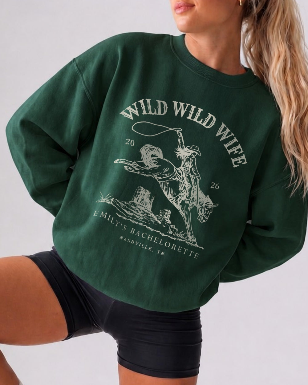 Crew-neck bachelorette sweatshirt with vintage western illustration and distressed texture for the Wild Wild Wife theme. Personalized with bride name, date, and destination city for the whole squad.