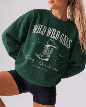 Matching sweatshirts for the bride and her country western bachelorette crew. Wild Wild Wife varsity-style design with cowboy boots graphic, customizable with year and destination city.
