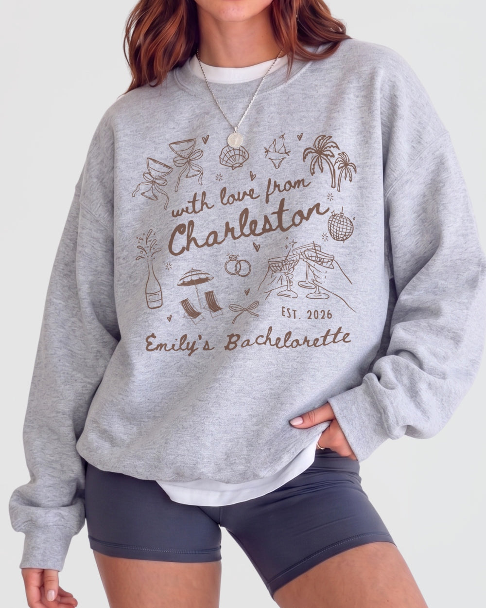 Bride and bridesmaids matching bachelorette sweatshirts with playful line-art doodles and script lettering. Personalized with bride name, destination city, and weekend date for the whole crew.