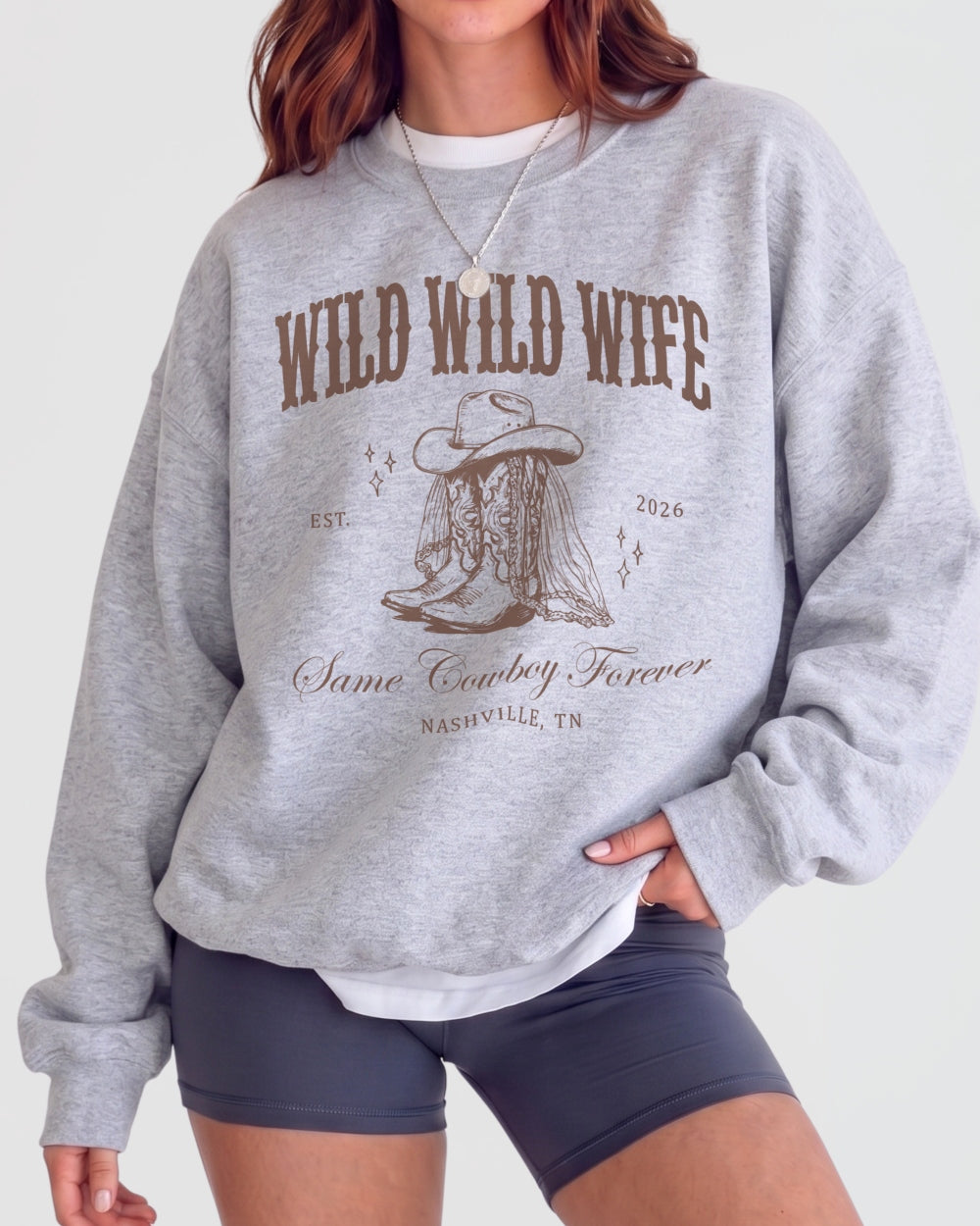 Bride and bridesmaids matching country western sweatshirts for a Wild Wild Wife bachelorette crew. Varsity-style lettering with vintage cowboy boots graphic, perfect for a Nashville girls weekend.