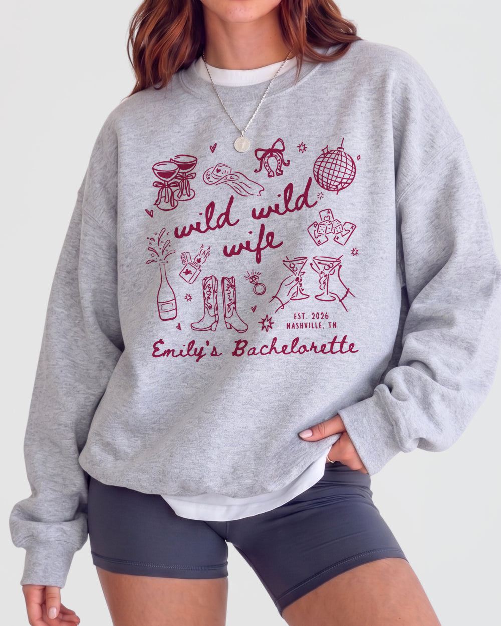 Bride and bridesmaids matching bachelorette sweatshirts with playful doodle art and Wild Wild Wife script. Personalize with the bride's name, year, and destination city for the whole crew.